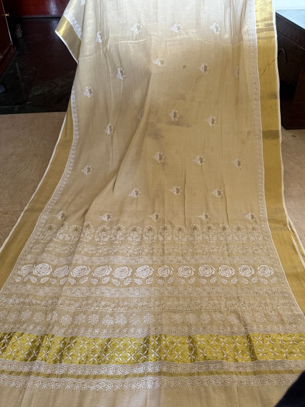 Off-white Kerala Kasavu saree with Chikankari & Jaali work motifs.